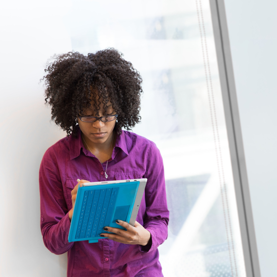 Woman in a purple dress shirt using a laptop